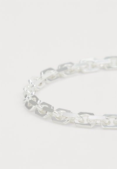 Silver chain bracelet made of linked oval and rectangular metal pieces, featuring a shiny polished finish and smooth texture.