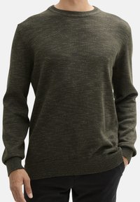 Pull en tricot vert olive avec un col rond, des poignets et un ourlet côtelés. Présente un motif texturé sur tout le tissu.