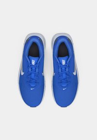 Μπλε αθλητικά παπούτσια με υφασμάτινο επάνω μέρος με υφή, γκρι λεπτομέρειες, στρογγυλεμένη μύτη και λευκό λογότυπο Nike στη πλευρά και τη γλώσσα. Σχεδιασμός με κορδόνια.