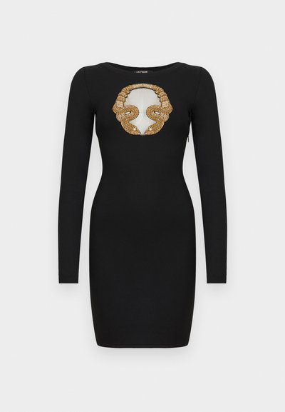 Μαύρο εφαρμοστό μίνι φόρεμα με μακριά μανίκια, στρογγυλή λαιμόκοψη και χρυσή παγιέτα σε σχέδιο φίδι που περιβάλλει ένα διαφανές τμήμα στο στήθος.
