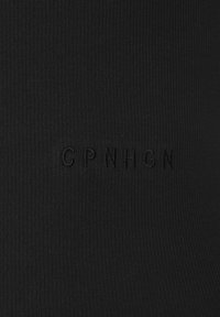 Black ribbed fabric with a textured surface. Features tonal embroidered lettering "CPNHGN" near the bottom.