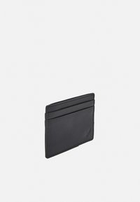 Black leather cardholder with four card slots. Smooth texture, minimal design, and subtle stitching detail. Compact rectangular shape.
