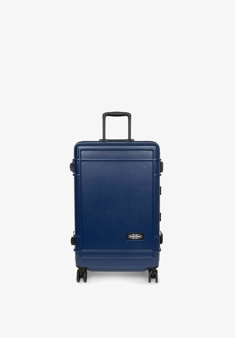 Navy blue hard-shell suitcase with a textured surface, extending handle, four wheels, and logo accent on the front.