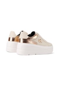Zapatillas plataformas con parte superior de piel beige y acentos metálicos en oro rosado. Suela blanca gruesa con detalles texturizados. Diseño con cordones.