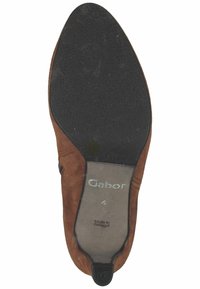 Semelle de chaussure en suède marron avec grip en caoutchouc noir, taille 4, marquée "Gabor," fabriquée au Portugal, vue de dessous.