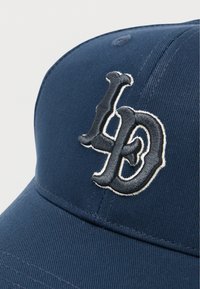 Μπλε ναυτικό καπέλο από υφασμάτινη υφή, με έντονο κεντητό λογότυπο "LD" σε σκούρο και ανοιχτό γκρι στο μπροστινό μέρος.