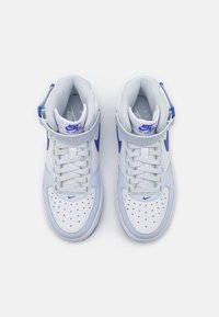 Sapatilhas Nike Air Force 1 em branco e azul claro. Apresentam colar acolchoado, biqueira perfurada, atacadores e realces no logótipo swoosh azul.