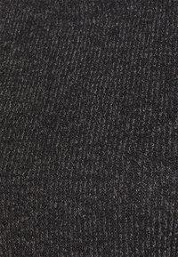 Tissu tricoté sombre avec une texture côtelée, présentant différentes nuances de charbon et des reflets subtils pour créer de la profondeur.