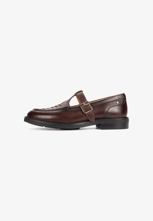 Mocasín de cuero marrón oscuro con correa lateral con hebilla y suela negra, con detalles tejidos en la parte superior frontal.