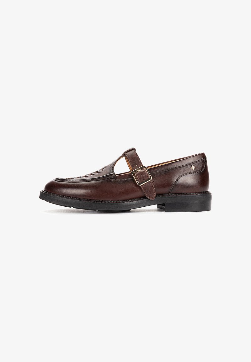 Mocassin en cuir brun foncé avec bride latérale à boucle et semelle noire, présentant des détails tissés sur la partie supérieure avant.