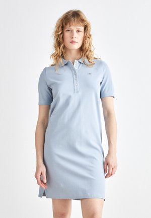Helles blaues Polo-Kleid mit kurzen Ärmeln, geknöpftem Kragen und gesticktem Logo. Verfügt über seitliche Schlitze für eine einfache Beweglichkeit und eine weiche Textur.