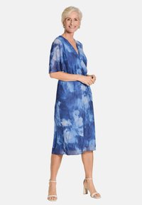 Robe portefeuille à fleurs bleues en tissu léger, avec de courtes manches kimono et un design fluide, agrémentée d'une texture douce et d'un ourlet longueur genou.