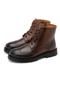 Brązowe skórzane botki z zapięciem na sznurówki, detalami w stylu brogue, okrągłym noskiem oraz solidną czarną gumową podeszwą. Gładkie i teksturowane wykończenie.