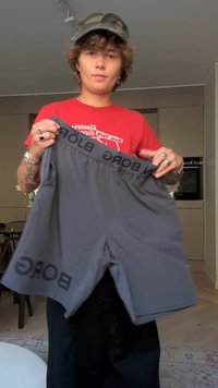 Γκρι αθλητικά σορτς με φαρδύ μαύρο λάστιχο που φέρει την επιγραφή "BORG" με έντονα γράμματα. Κατασκευασμένα από ελαφρύ, αναπνεύσιμο υλικό.