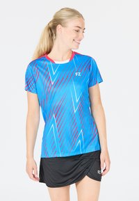 Blå idrottströja med rosa och vita diagonala ränder, rund halsringning, korta ärmar. Bärs med en svart kjol som har logotyp vid midjan.