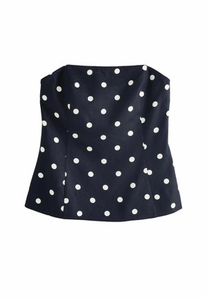 Navy blue strapless top featuring white polka dots, with structured bodice, seam details, and a slightly flared hemline.