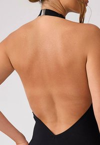 Czarny, kostium kąpielowy z niskim plecami i dekoltem na halter, charakteryzujący się gładką fakturą oraz srebrną zapięci na szyi.