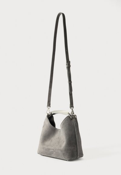 Grå ruskinds håndtaske med et sølvmetal håndtag og justerbar rem, der har en blød tekstur og en afrundet silhuet.