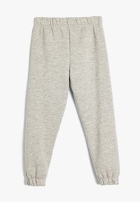 Pantalones de chándal grises hechos de una tela suave, con cinturilla elástica y puños en los tobillos. Textura suave con un patrón jaspeado.