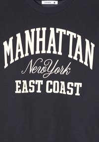 Felpa di un intenso blu navy con ampio testo bianco: "MANHATTAN", "New York" e "EAST COAST." Collo a giro e tessuto morbido.