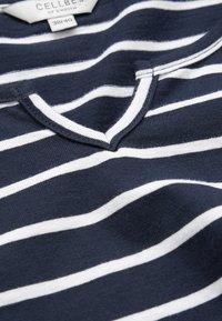 Navyblau-weiß gestreiftes Baumwollhemd mit V-Ausschnitt, das eine weiche Textur und gleichmäßig verteilte horizontale Streifen aufweist. Größe 38/40.