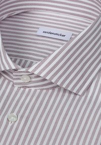Chemise blanche habillée avec fines rayures verticales marron, boutons en perle et une étiquette visible portant la mention "seidensticker" à l’intérieur du col.