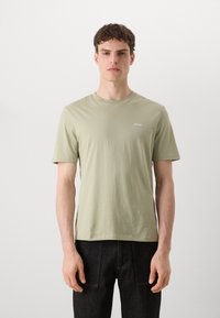 Lysegrøn kortærmet t-shirt lavet af blødt bomuld, med rund halsudskæring og et lille hvidt "HUGO" logo på brystet.