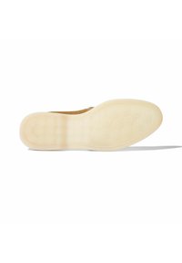 Scarpa in suede con suola in gomma leggera e texture; presenta un motivo di trazione circolare e un bordo liscio. Il colore è un marrone tenue.