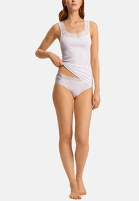 Jasnoszara bluzka na ramiączkach z koronkowym wykończeniem na ramionach, w zestawie z dopasowanym bikini z koronkowymi akcentami. Miękki materiał, przylegający krój. Brak widocznych elementów metalowych.