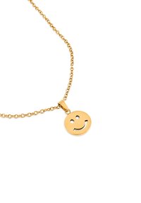 Złoty naszyjnik z okrągłą zawieszką w kształcie uśmiechniętej twarzy. Zawieszka ma wycięty wzór uśmiechniętej twarzy. Ogniwa łańcucha są małe i równomiernie rozmieszczone.