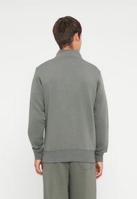 Grijze sweatshirt met een hoge kraag, ribgebreide manchetten en onderrand, gemaakt van zacht materiaal. Beschikt over een strak ontwerp met een relaxed fit.