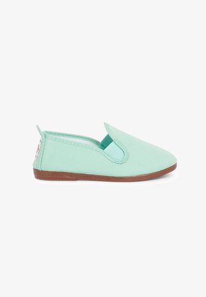 Scarpa slip-on in tela verde menta con punta arrotondata e suola in gomma marrone; presenta pannelli laterali elasticizzati e una piccola etichetta del marchio sul tallone.