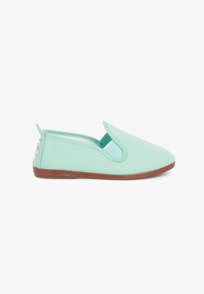 Scarpa slip-on in tela verde menta con punta arrotondata e suola in gomma marrone; presenta pannelli laterali elasticizzati e una piccola etichetta del marchio sul tallone.