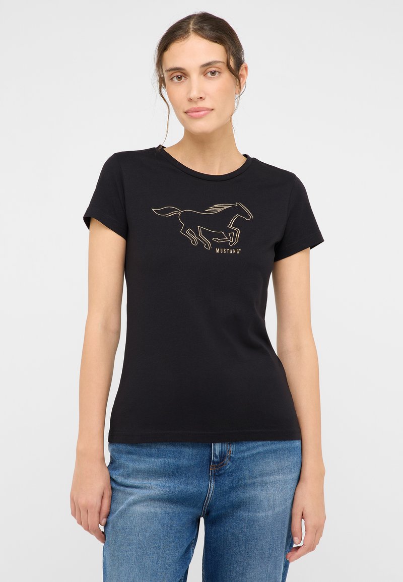 Juodas medvilninis marškinėliai su auksiniu bėgančio arklio kontūru ir užrašu "MUSTANG". Trumpomis rankovėmis ir apvaliu kaklu, prigludusi forma.