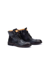 Botas de tobillo de cuero negro con cremallera lateral, parte delantera con cordones, interior marrón y acento marrón en la suela. Paneles texturizados a los lados.