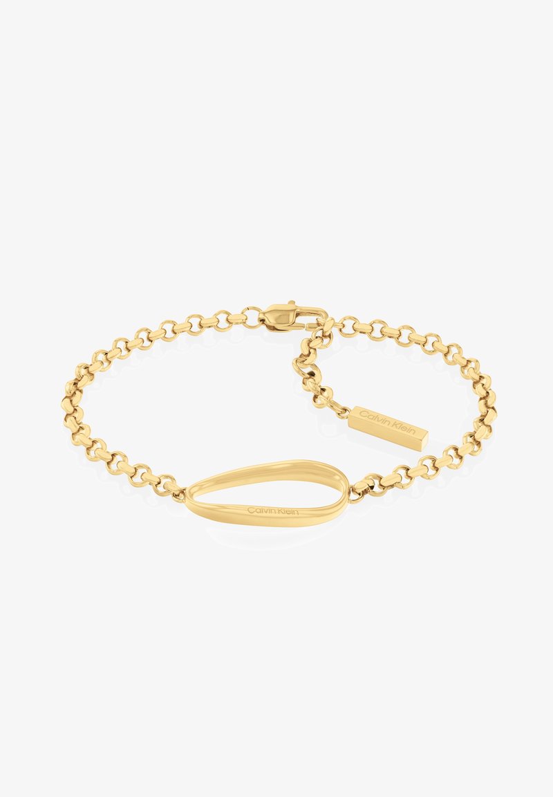 Bracelet doré avec un design en chaîne, accent ovale et une étiquette rectangulaire gravée "Calvin Klein". Texture lisse et finition polie.