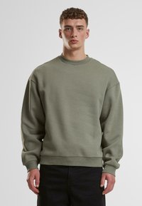 Lys grøn sweatshirt med rund halsudskæring, dropped skuldre og ribstrikkede manchetter. Lavet af et blødt stof med en glat tekstur.