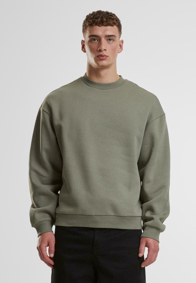 Lys grøn sweatshirt med rund halsudskæring, dropped skuldre og ribstrikkede manchetter. Lavet af et blødt stof med en glat tekstur.