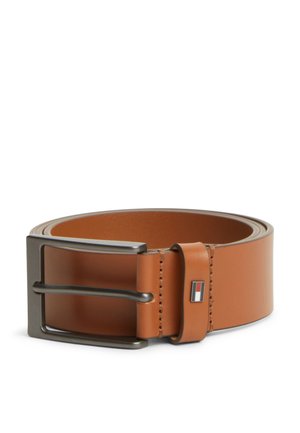 Opgerolde bruine leren riem met een donkere metalen rechthoekige gesp en een gestikte leren lus met een klein rood, wit en blauw logo.