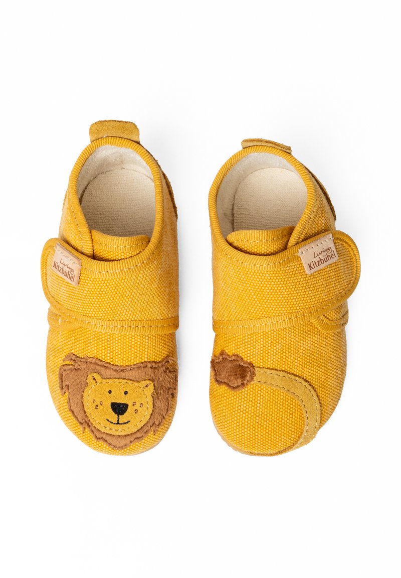 Scarpe in tessuto giallo con design di leone, caratterizzate da una texture morbida, strap con velcro e una fodera naturale. Dettagli accentuati includono il volto di un leone.