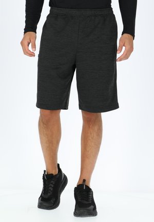 Graue Sportshorts mit elastischem Bund, knielangem Design und strukturierter Stoffbeschaffenheit. Getragen mit schwarzen Sportschuhen.