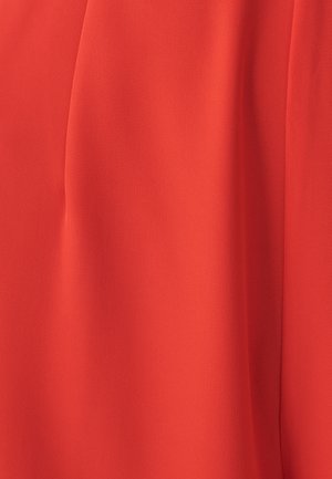 Rød stof med en glat, let tekstureret overflade, der har bløde draperinger og en subtil glans, velegnet til tøj eller accessories.