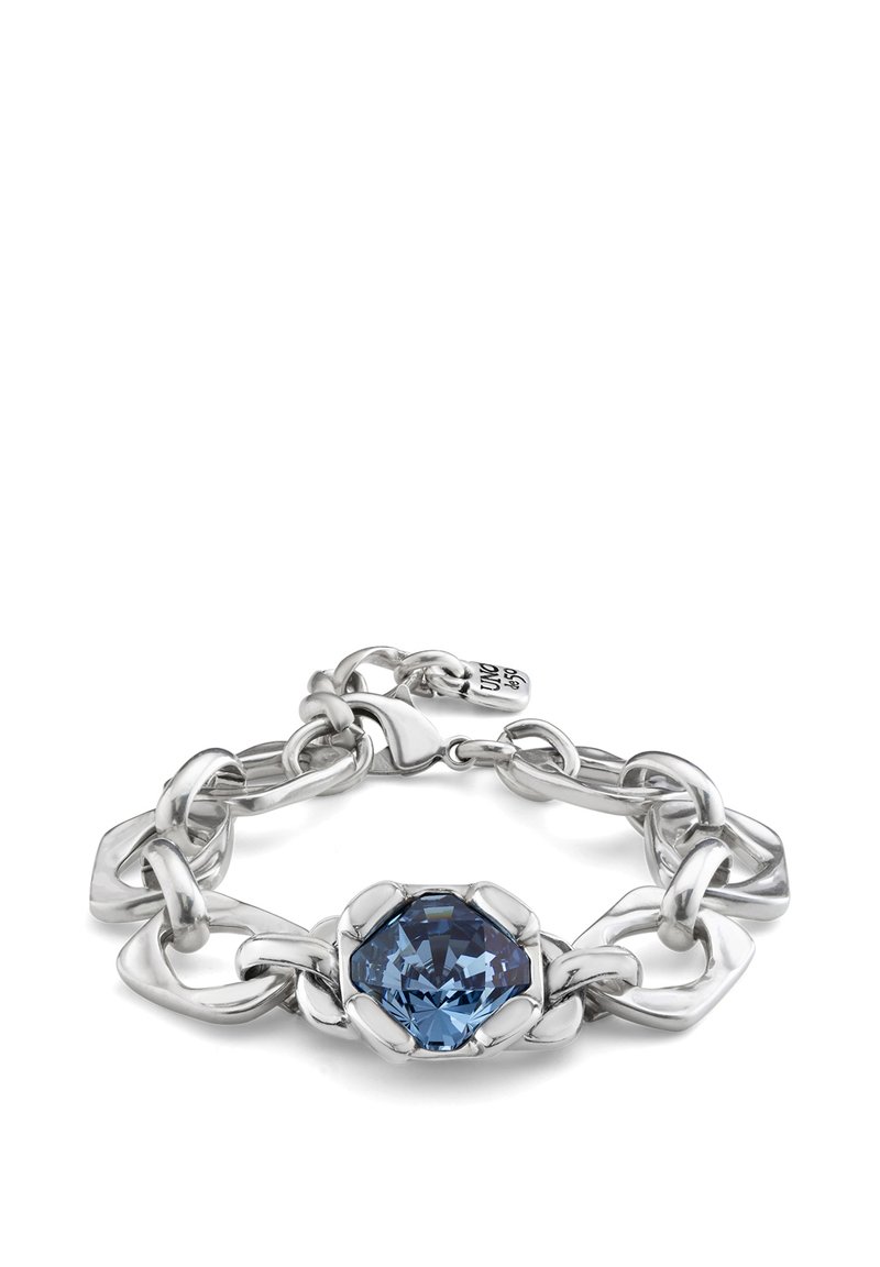 Pulsera de plata con grandes eslabones entrelazados, un cristal azul octagonal central y un cierre seguro con una etiqueta de marca adjunta.