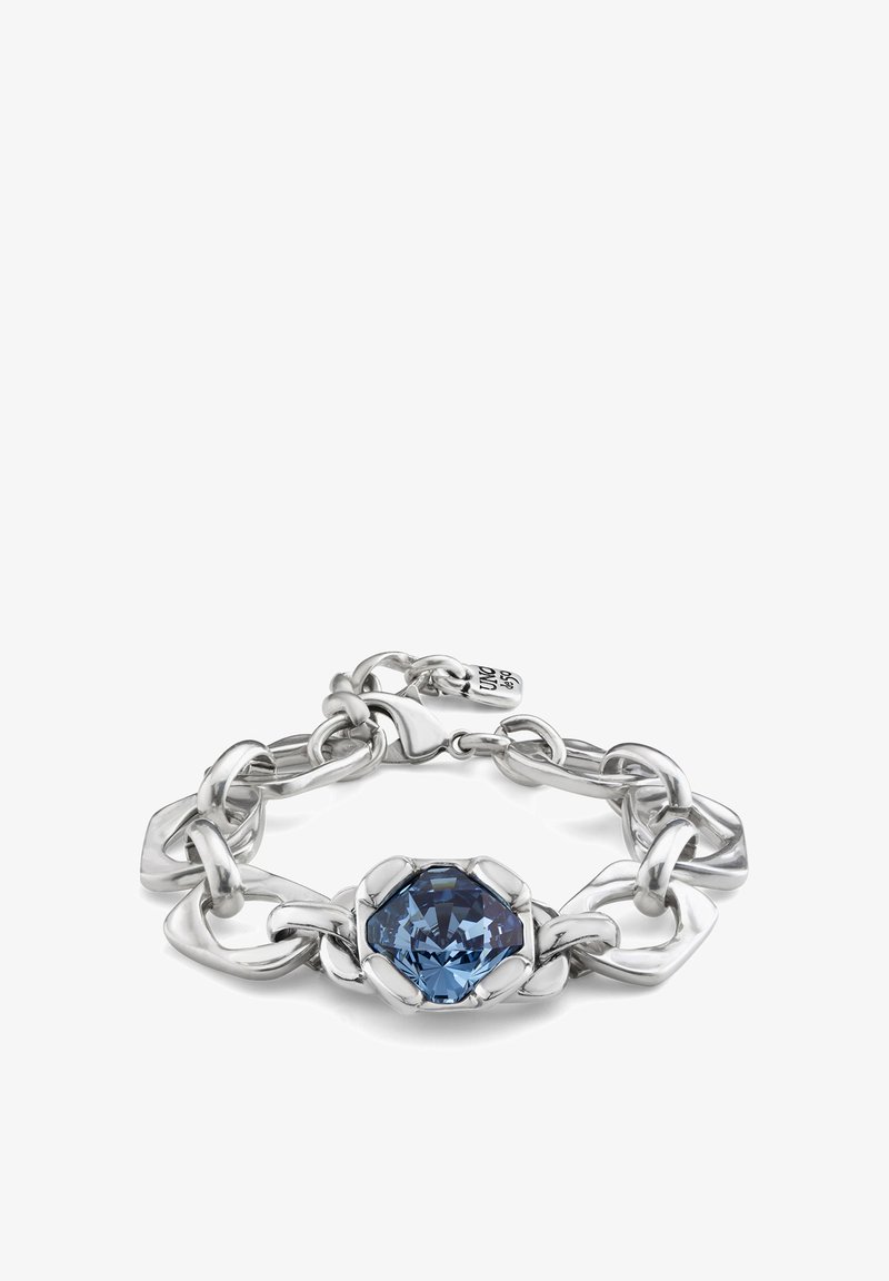 Pulsera de plata con grandes eslabones entrelazados, un cristal azul octagonal central y un cierre seguro con una etiqueta de marca adjunta.