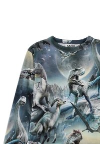 Långärmad skjorta med ett färgglatt dinosauriemönster, med olika arter som T. rex, Triceratops och flygande pterosaurier mot en månbelyst bergig bakgrund.