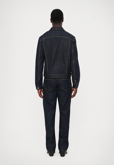 Mørkeblå denimjakke og matchende jeans. Jakken har en skræddersyet pasform, knapdetaljer og baglomme. Glat tekstur med minimal slid.