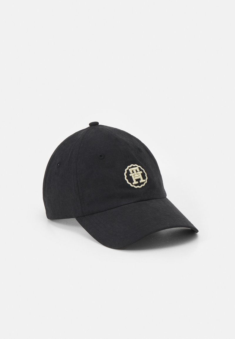 Casquette de baseball noire avec une visière courbée et un petit logo rond avec des lettres entrelacées beige sur le panneau avant.