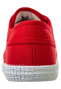 Scarpa di tela rossa con tomaia texturizzata, suola in gomma bianca a contrasto e dettagli cuciti lungo il tallone e i bordi.