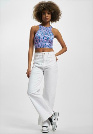 Modrý a růžový vzorovaný crop top s halter krkem; bílé vysoké široké džíny; černé a šedé tenisky.