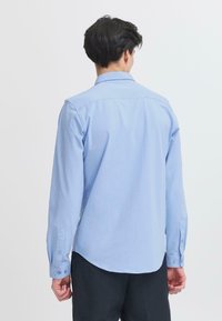 Lichtblauwe langemouwen shirt van katoen met een rechte snit, knoopmanchetten en een klassieke kraag, met een gladde textuur en zonder patronen.